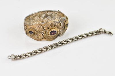Lot 558 - A white metal filigree snap bangle set with...