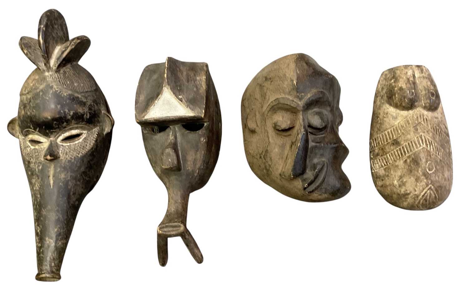 Lot 1002 - Four African carved wooden tribal masks,