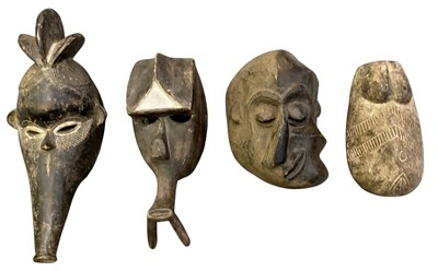 Lot 1002 - Four African carved wooden tribal masks,...