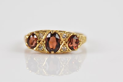 Lot 2459 - An 18ct yellow gold garnet and diamond set...