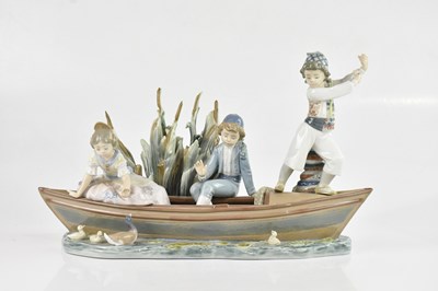 Lot 1633 - LLADRO; a figure group of children on a rowing...