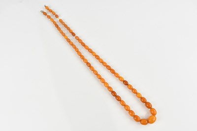 Lot 2112 - A butterscotch amber coloured bead necklace,...