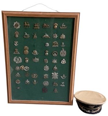 Lot 377 - A framed montage of military cap badges,...