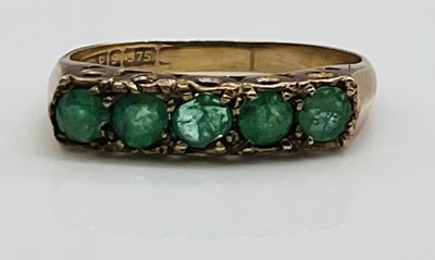 Lot 639 - A 9ct yellow gold and five stone emerald ring,...