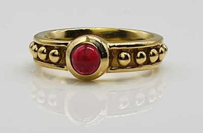 Lot 701 - A yellow metal and ruby cabochon ring with...