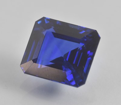 Lot 1311 - A loose emerald cut 20ct sapphire, with no...