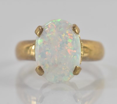 Lot 1251 - A 9ct yellow gold oval white opal set ring,...