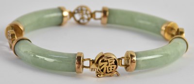 Lot 1310 - A Chinese jade and 14K yellow gold mounted...