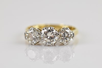 Lot 2247 - An 18ct yellow gold diamond three stone dress...