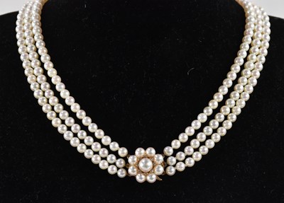 Lot 1264 - A triple row cultured pearl necklace, with...