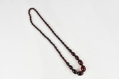 Lot 2217 - A cherry amber coloured beaded necklace,...