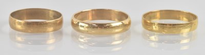 Lot 1214 - Three 9ct yellow gold wedding bands, sizes M...