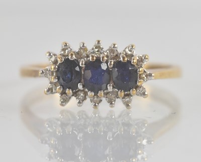 Lot 1238 - A 9ct yellow gold three stone sapphire and...