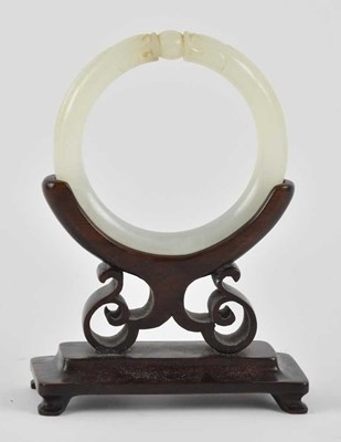 Lot 1022 - A Chinese carved white jade bangle, carved...