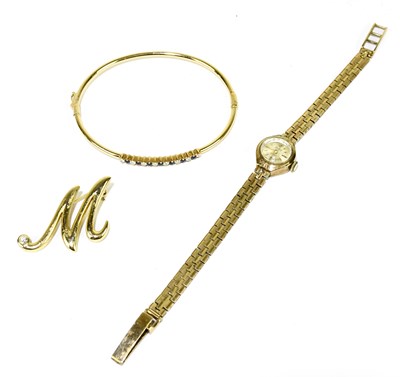 Lot 1265 - A 14ct yellow gold oval bangle set with small...