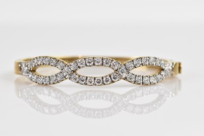 Lot 1139 - A 9ct yellow gold hinged snap bangle, set with...