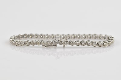 Lot 1149 - A 9ct white gold tennis bracelet, set with...