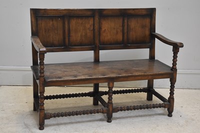 Lot 121 - A reproduction oak settle, the seat with...