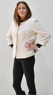 Lot 169 - CHANEL; a cream and dusky pink bouclé tweed...