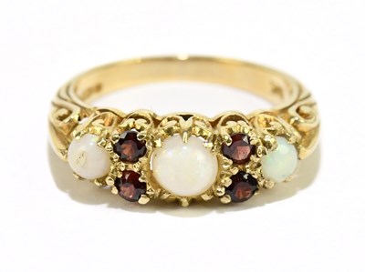 Lot 1211 - A 9ct yellow gold garnet and opal ring, size M,...