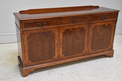 Lot 152 - A reproduction yew wood sideboard with three...