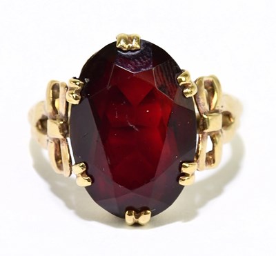 Lot 1077 - A 9ct yellow gold and garnet dress ring, size...