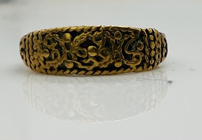 Lot 595 - An early yellow metal ring with unusual relief...
