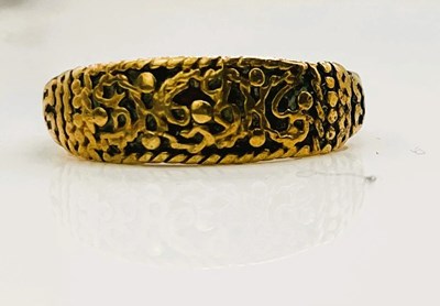 Lot 689 - An early yellow metal ring with unusual relief...