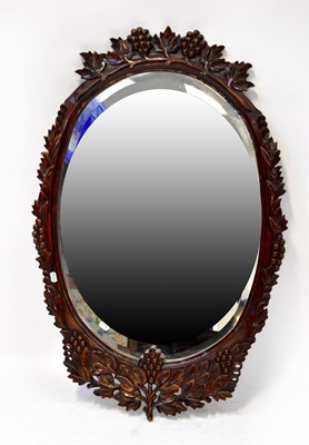 Lot 76 - A reproduction oval wall mirror with bevelled...