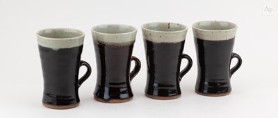 Lot 229 - Leach Pottery; a set of four tall stoneware...