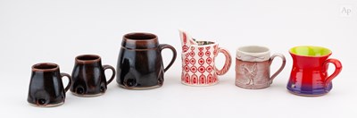 Lot 750 - A group of stoneware and earthenware mugs by...