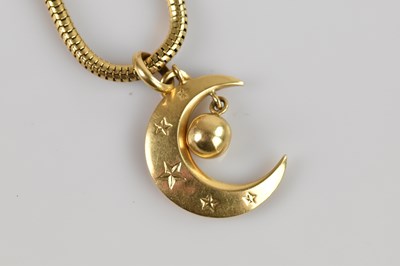 Lot 2060 - A yellow metal half moon pendant, stamped '750'...