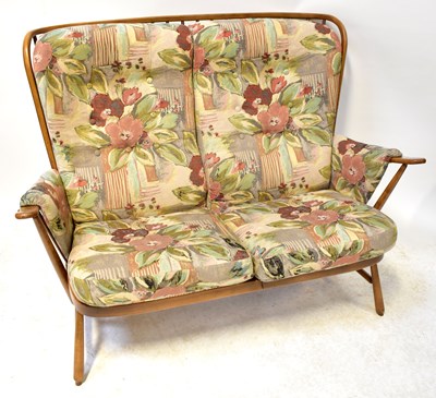 Lot 7 - ERCOL; a mid-coloured elm comb back settee,...