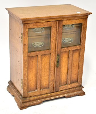 Lot 267 - An Edwardian oak tobacco cabinet, the glazed...