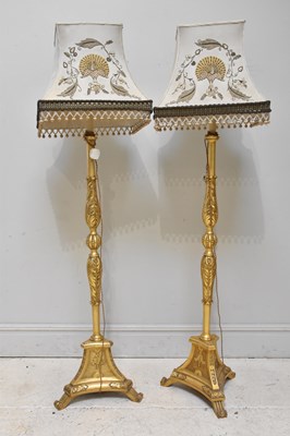 Lot 2027 - A pair of giltwood standard lamps, with silk...