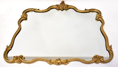 Lot 73 - A gilt framed wall mirror of shaped form,...