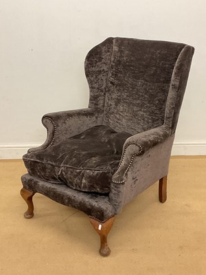 Lot 751 - An upholstered wingback armchair with stud...
