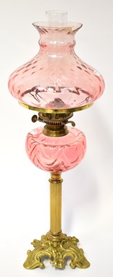 Lot 84 - A cranberry glass oil lamp with glass shade...