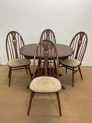 Lot 779 - ERCOL; an extending table and four Windsor...