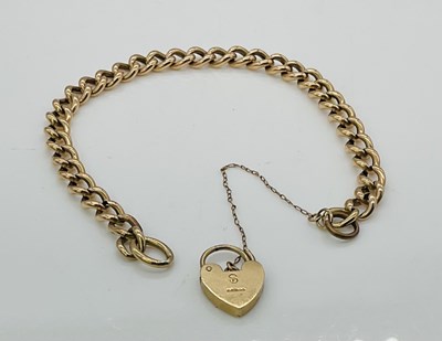 Lot 615 - A 9ct gold curb link bracelet, with heart...