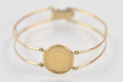 Lot 1452 - A 9ct yellow gold bangle, set with 1991 1/10...