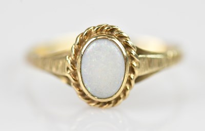 Lot 2593 - A 9ct yellow gold opal set dress ring, size O,...