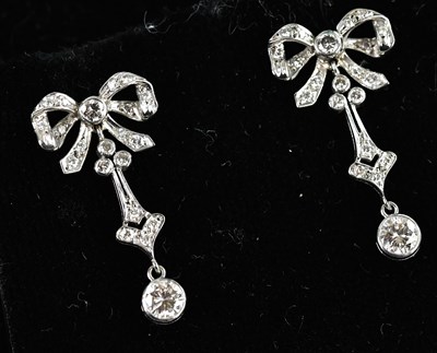 Lot 1361 - A pair of white metal diamond set bow drop...