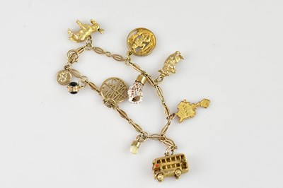 Lot 1171 - A yellow metal charm bracelet, stamped '9ct',...