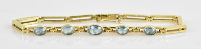 Lot 1173 - A yellow metal blue topaz set bracelet,...