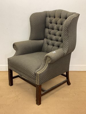 Lot 750 - An upholstered wingback armchair on a mahogany...