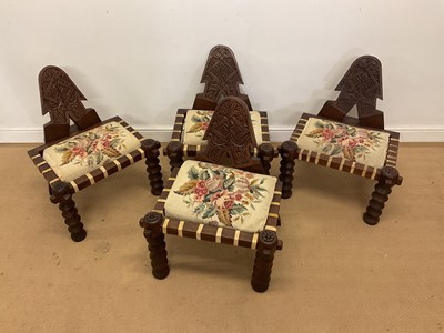 Lot 266 - A set of four African carved hardwood low...
