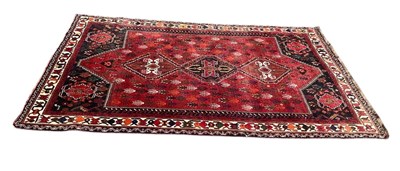 Lot 399 - A red ground Eastern style carpet with central...