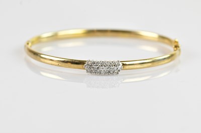 Lot 1198 - A yellow metal diamond set hinged snap bangle,...