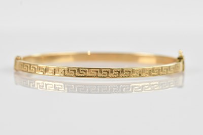 Lot 1215 - A 9ct yellow gold hinged snap bangle, with...